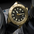 Men's vintage bronze automatic diving watch with gold dial and genuine leather strap on a wooden surface