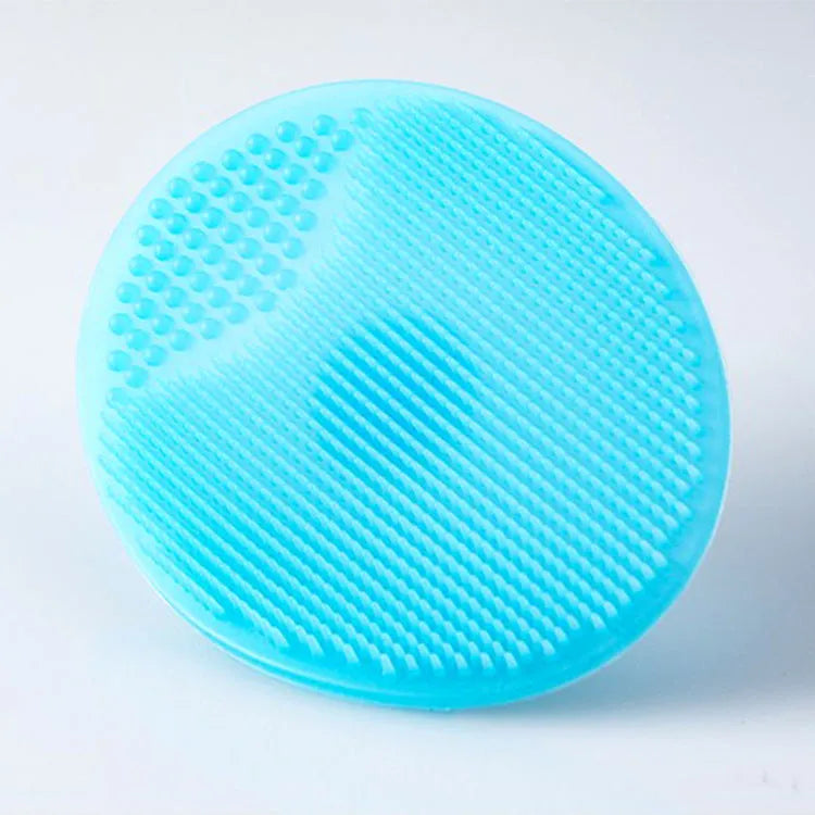Silicone facial brush in three bristle zones with suction cup on blue background