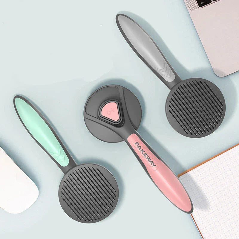 Ergonomic pet grooming brush in mint green, cherry blossom powder, and gentleman grey