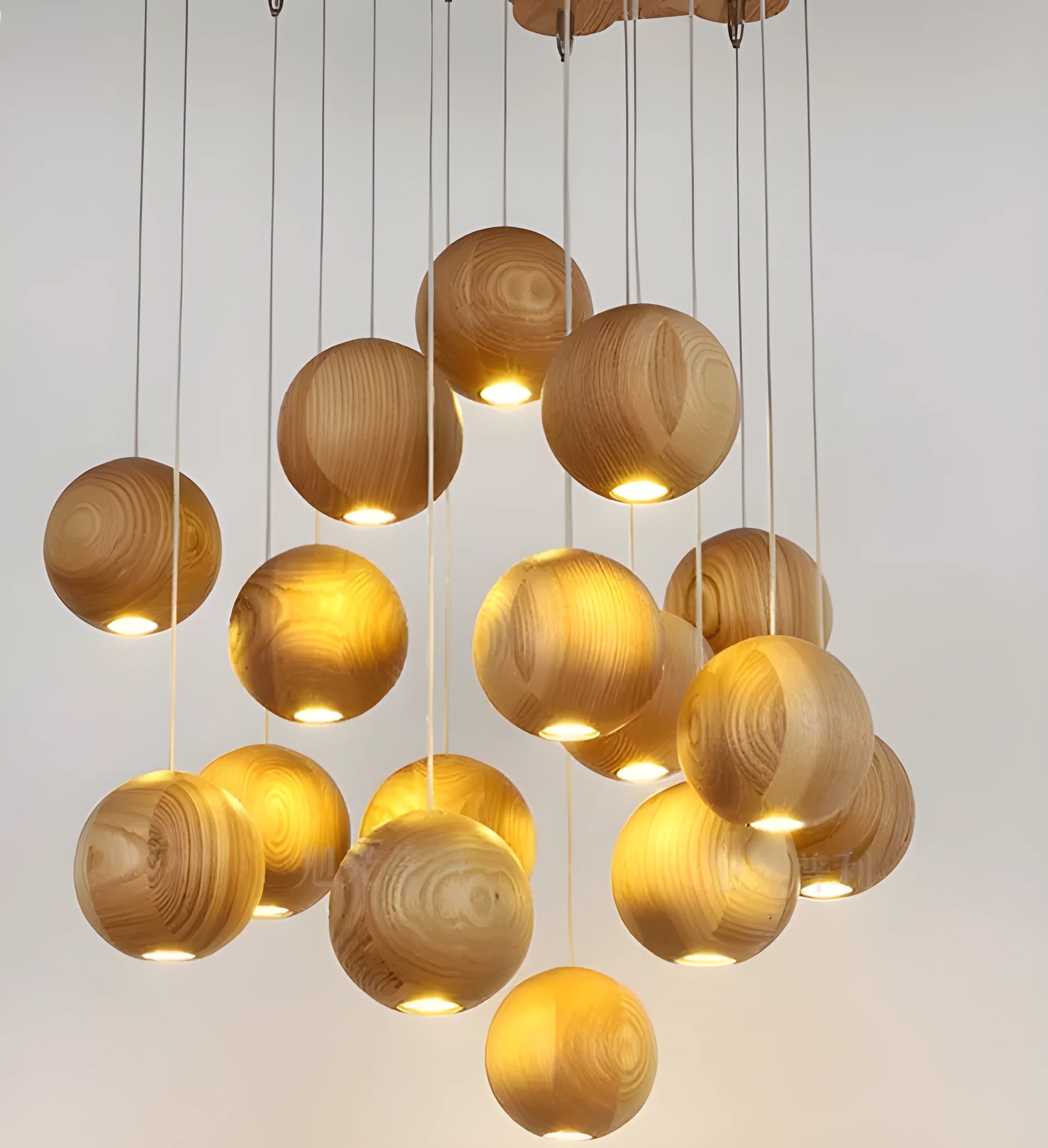 Nordic style solid wood ball chandelier hanging from a ceiling with an adjustable cord.