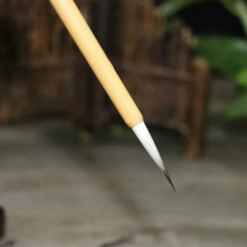 Set of four gold-coloured writing brushes with mixed hair bristles for calligraphy.