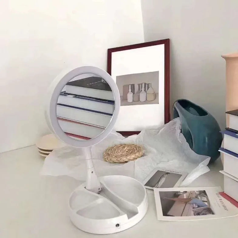 White acrylic LED vanity mirror with double-sided magnification and foldable storage compartments.