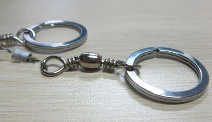 Stainless steel survival wire saw with pull rings, showing coiled 55 cm blade.