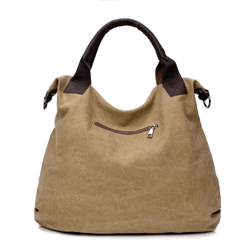 Women's canvas handbag in lake blue with zipper closure, hard handle, and double strap roots for shoulder or crossbody carry