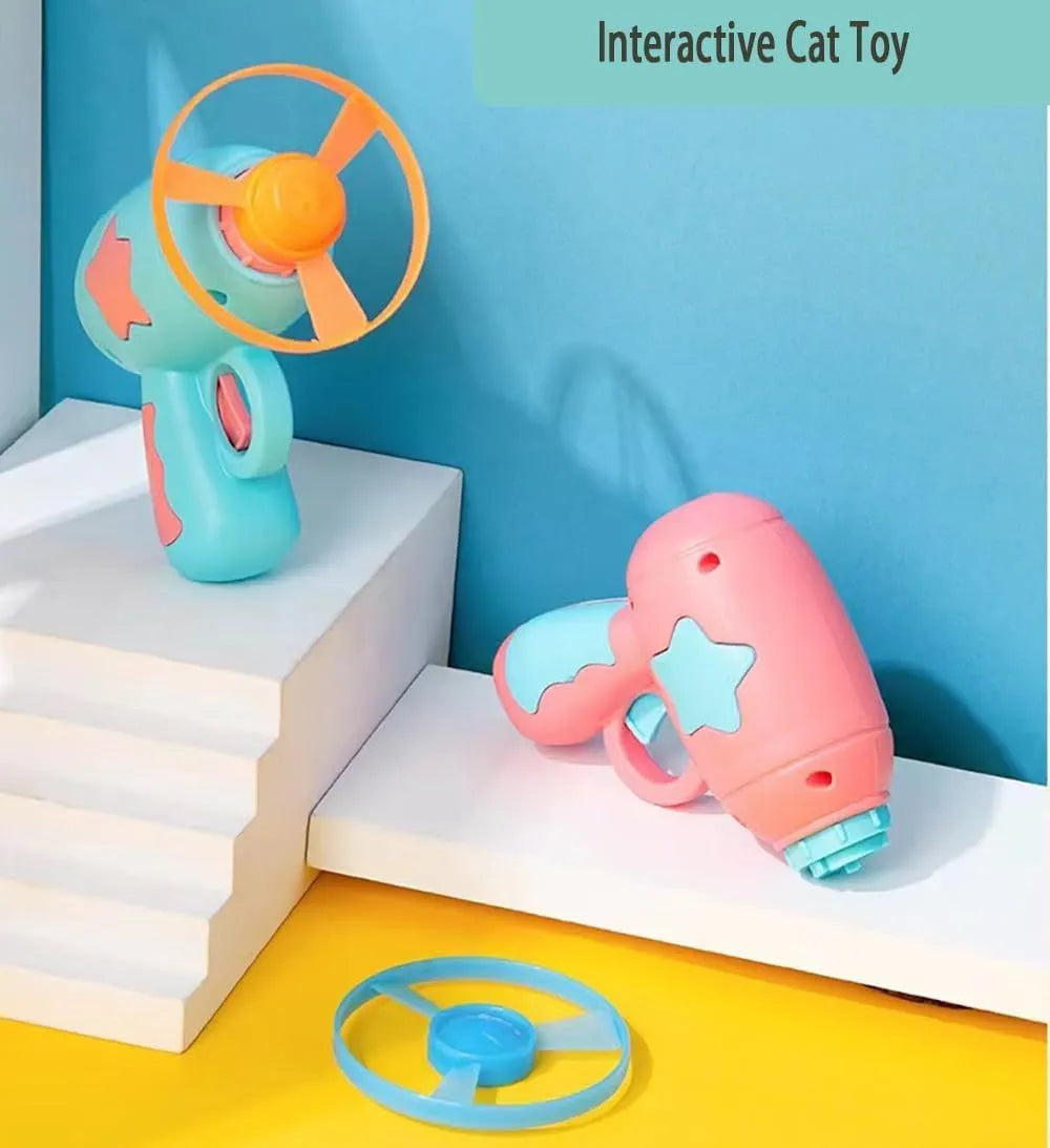 Blue interactive cat toy gun with a plastic frisbee on the launch head, shown next to a second pink frisbee.