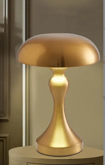 Metallic bronze LED desk lamp with touch control on a wooden desk next to a book.