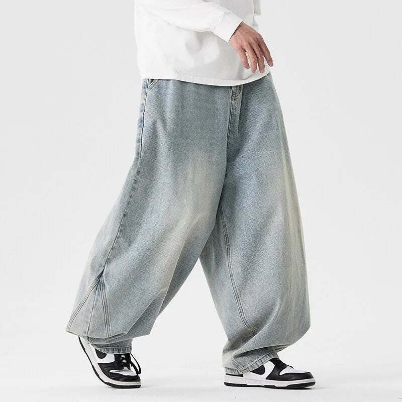 Men's plus-size light blue wide-leg denim jeans with a loose, baggy fit and straight legs on a hanger.