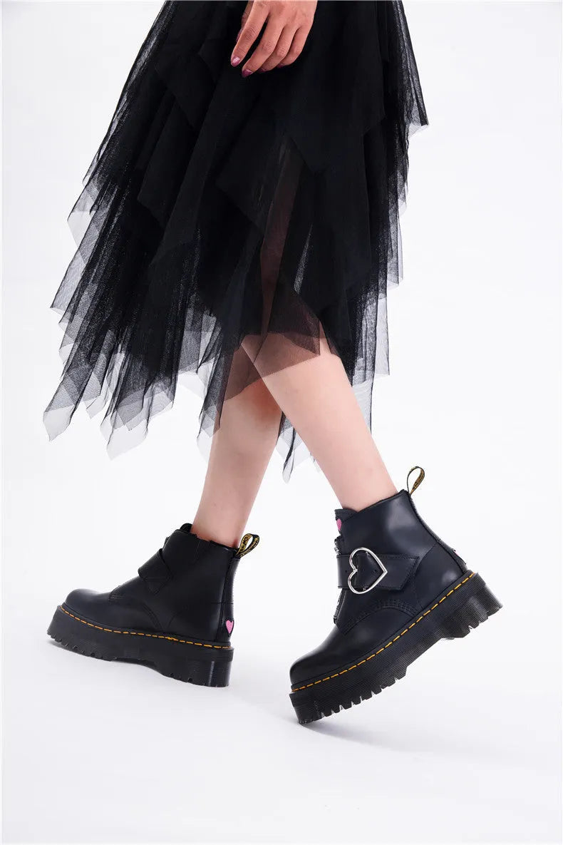 Women's black leather ankle boots with chunky heel, lace-up front, side zip, and belt buckle detail on a waterproof platform