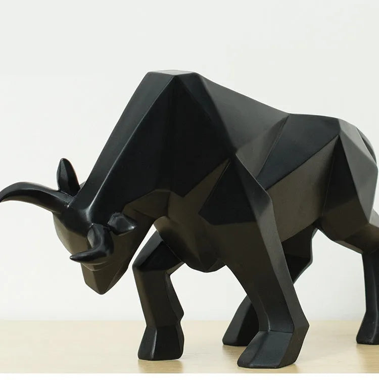 Modern geometric resin bull sculpture in black with abstract angular design on a neutral background