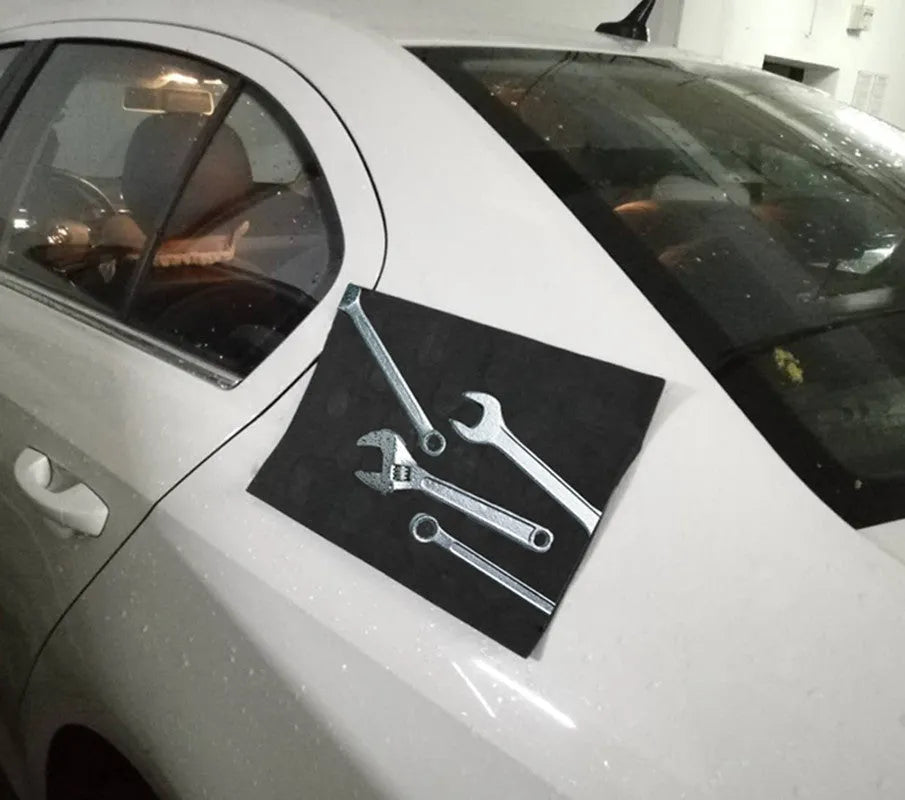 Magnetic pad 300x200x3mm in black, holding metal tools on a car bonnet