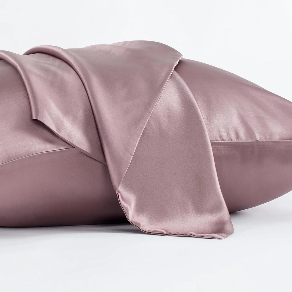 Dark grey mulberry silk pillowcase with envelope closure, shown in a modern bedroom setting.
