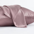Dark grey mulberry silk pillowcase with envelope closure, shown in a modern bedroom setting.