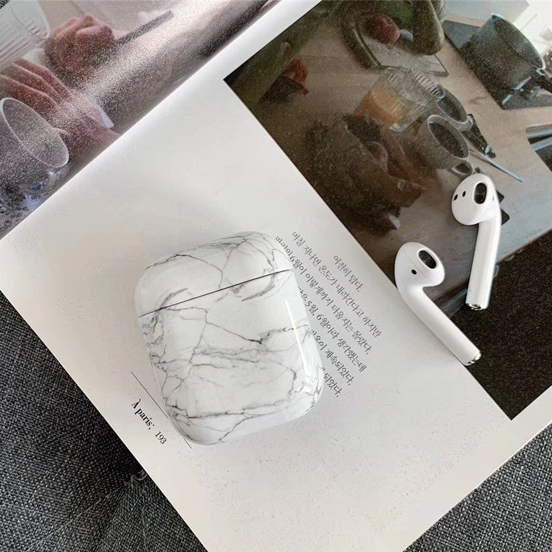 White marble pattern AirPods protective case with hard PC construction showing charging port access