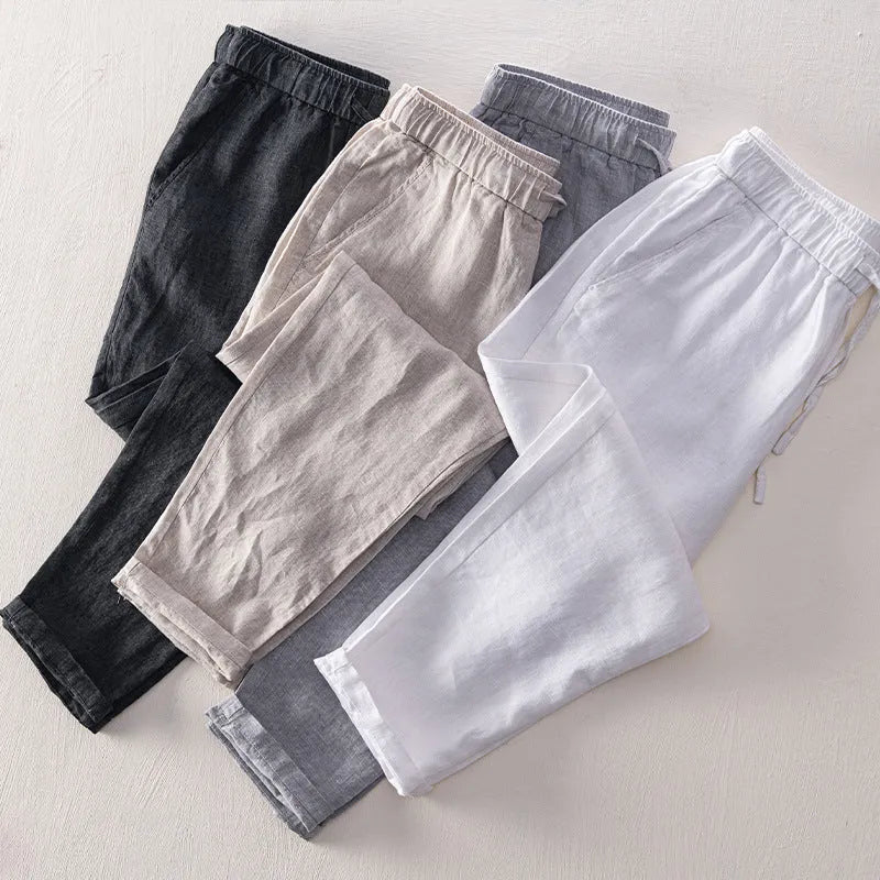 Men's straight-leg linen trousers in dark grey laid flat, showing mid waist and relaxed fit