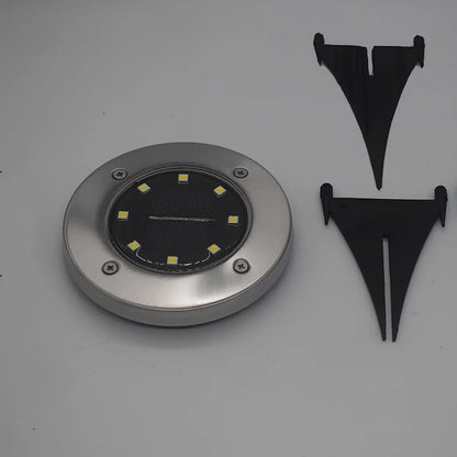 8LED waterproof solar garden light staked in lawn with warm glow, IP65 rated for rain resistance