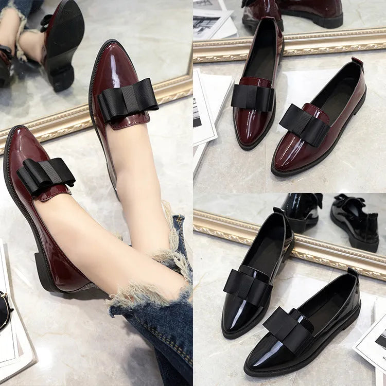 Women's patent leather pointed toe bowtie flats in black on a white background