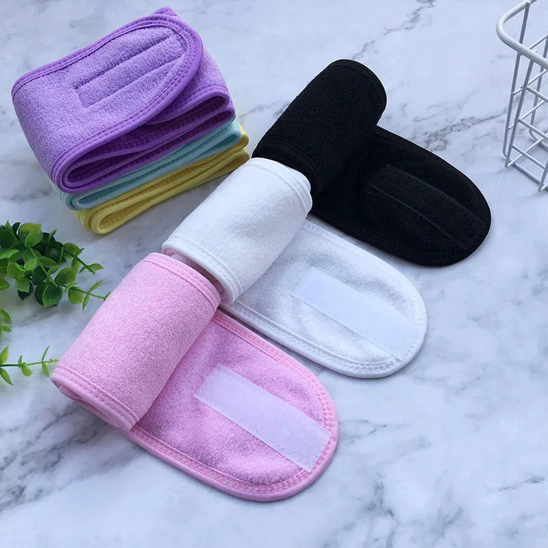 Thickened ant fabric beauty headband in white, pink, blue, purple, yellow on soft surface