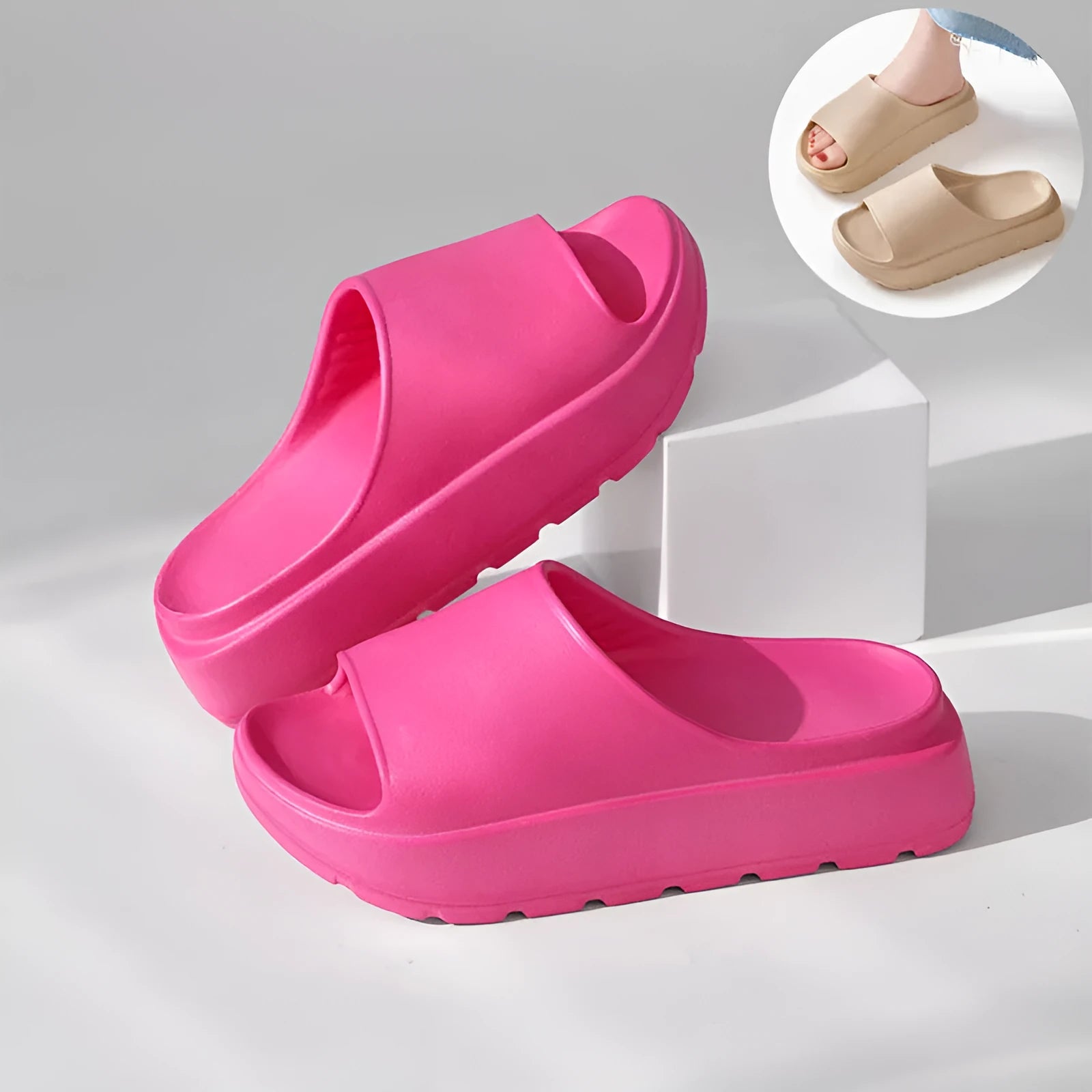 Women's beige thick-soled beach slippers with a fish mouth design on a wooden floor.