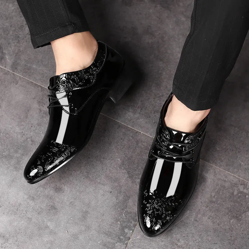Glossy black men's formal shoes with pointed toe, low top, and carved detail on microfiber leather upper