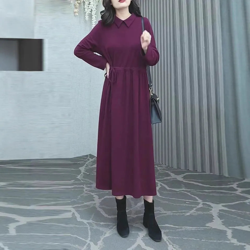 Purplish red women's plus size long sleeve dress with a long skirt on a hanger.