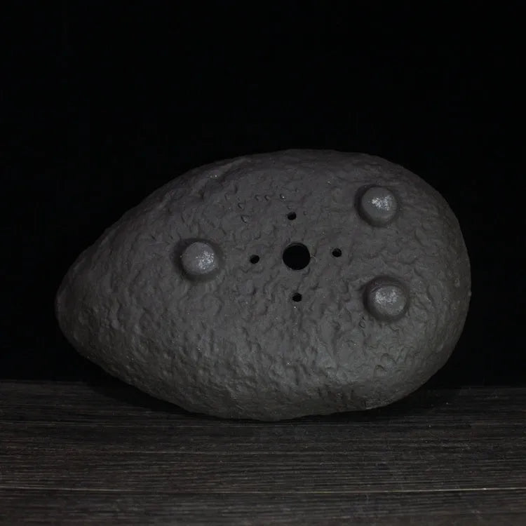 Handmade purple clay flower pot showing unique shape and texture