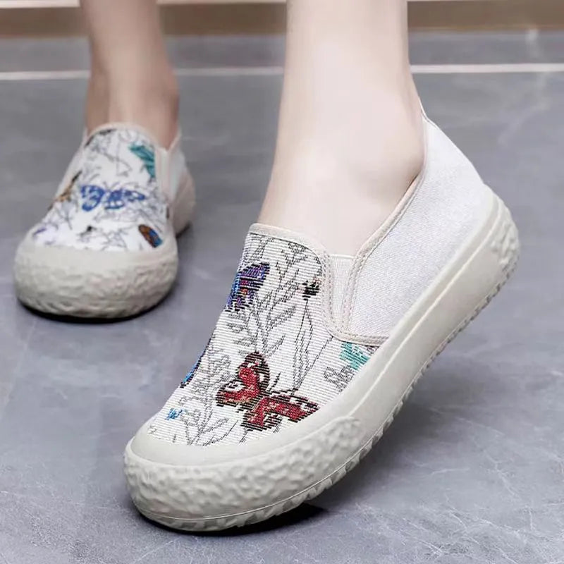 Women's canvas slip-on shoes with plastic soles in black and white colours showing sewing thread decoration
