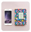 Green floral notepad with fabric imitation leather cover lying open on a table