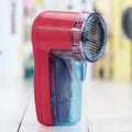 Portable electric clothing lint remover and fabric shaver on a white background.