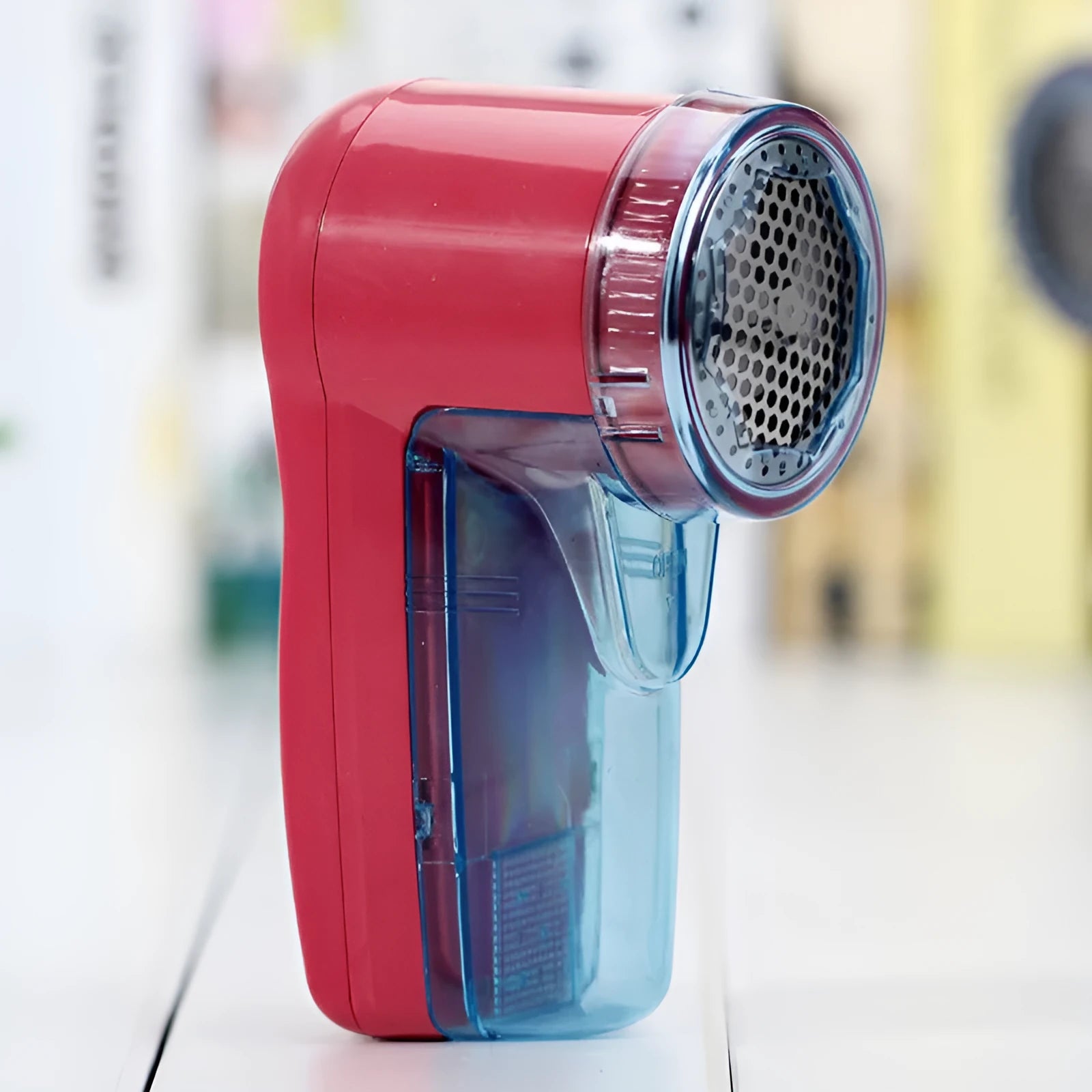 Portable electric clothing lint remover and fabric shaver on a white background.
