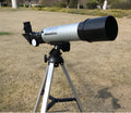 Silver telescope on aluminium tripod with multiple eyepieces and moon lens for stargazing
