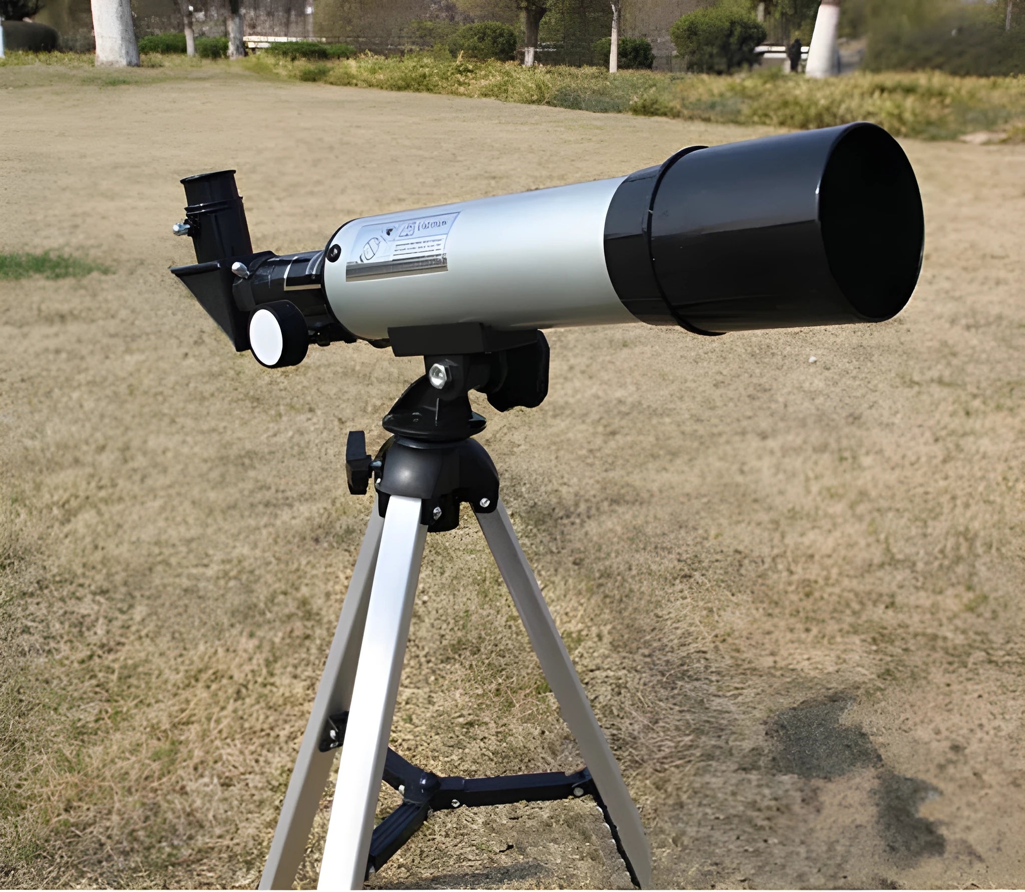 Silver telescope on aluminium tripod with multiple eyepieces and moon lens for stargazing