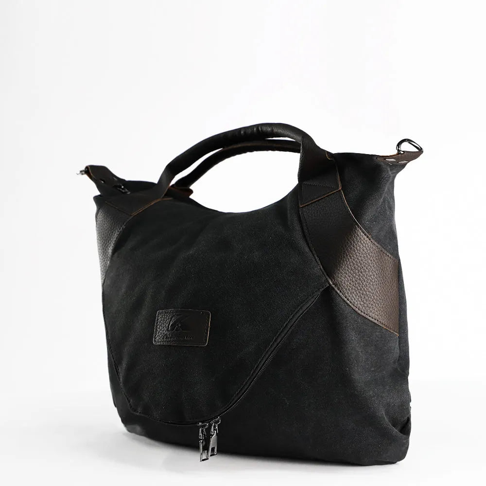 Women's canvas handbag in lake blue with zipper closure, hard handle, and double strap roots for shoulder or crossbody carry