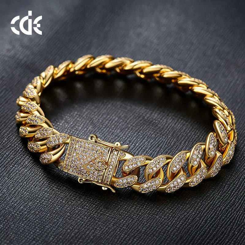 Men's Cuban chain bracelet with gold finish and geometric zircon pendant on a flat surface