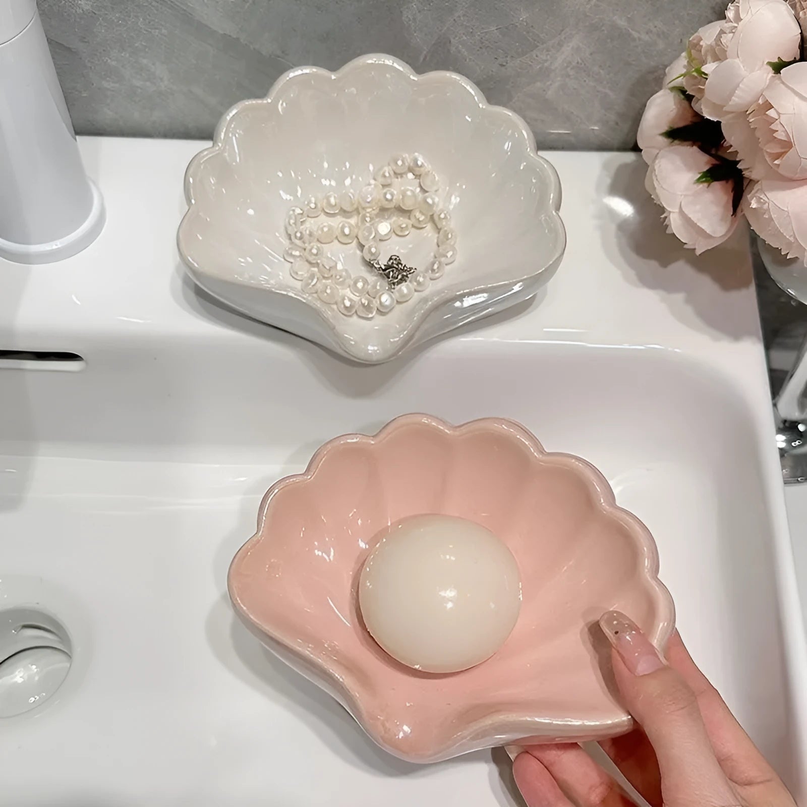 Shell-shaped plastic soap dish in pearl white or cherry blossom pink for bathroom use