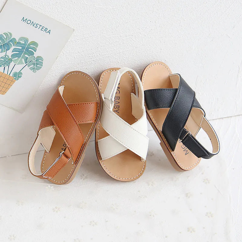 Children's cross strap Velcro sandals in brown, PU upper, beef tendon sole, side view on beach