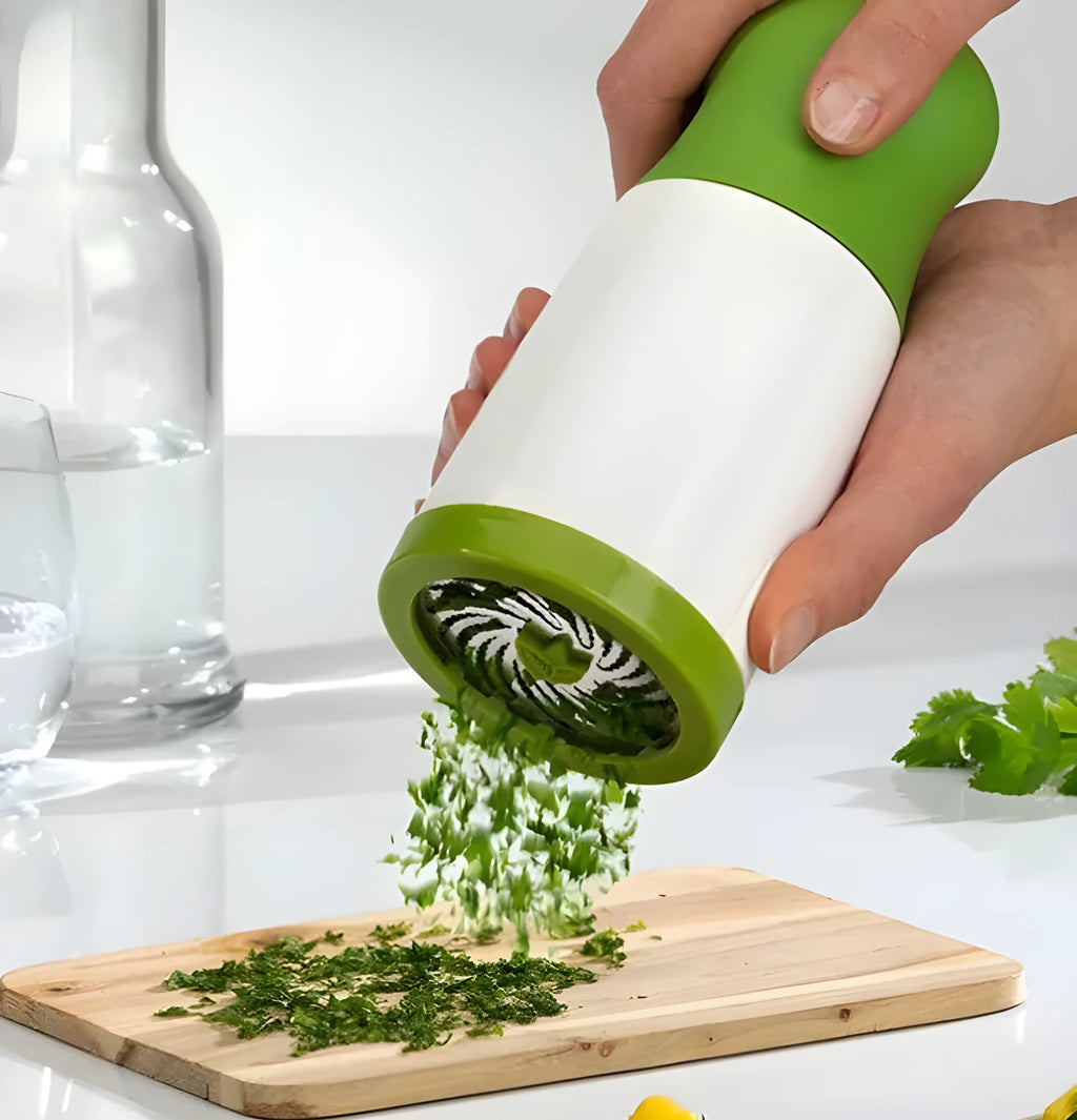 White and silver handheld herb grinder with removable top on a kitchen counter.