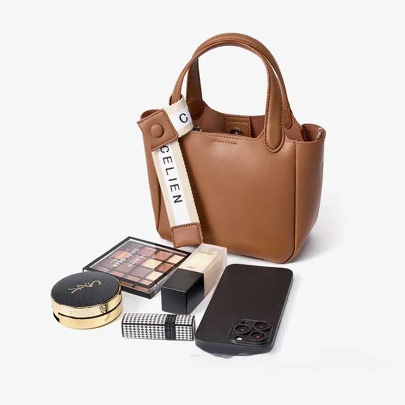 Brown genuine cattlehide leather cross body bucket bag showing sewing thread detail and slit pocket.