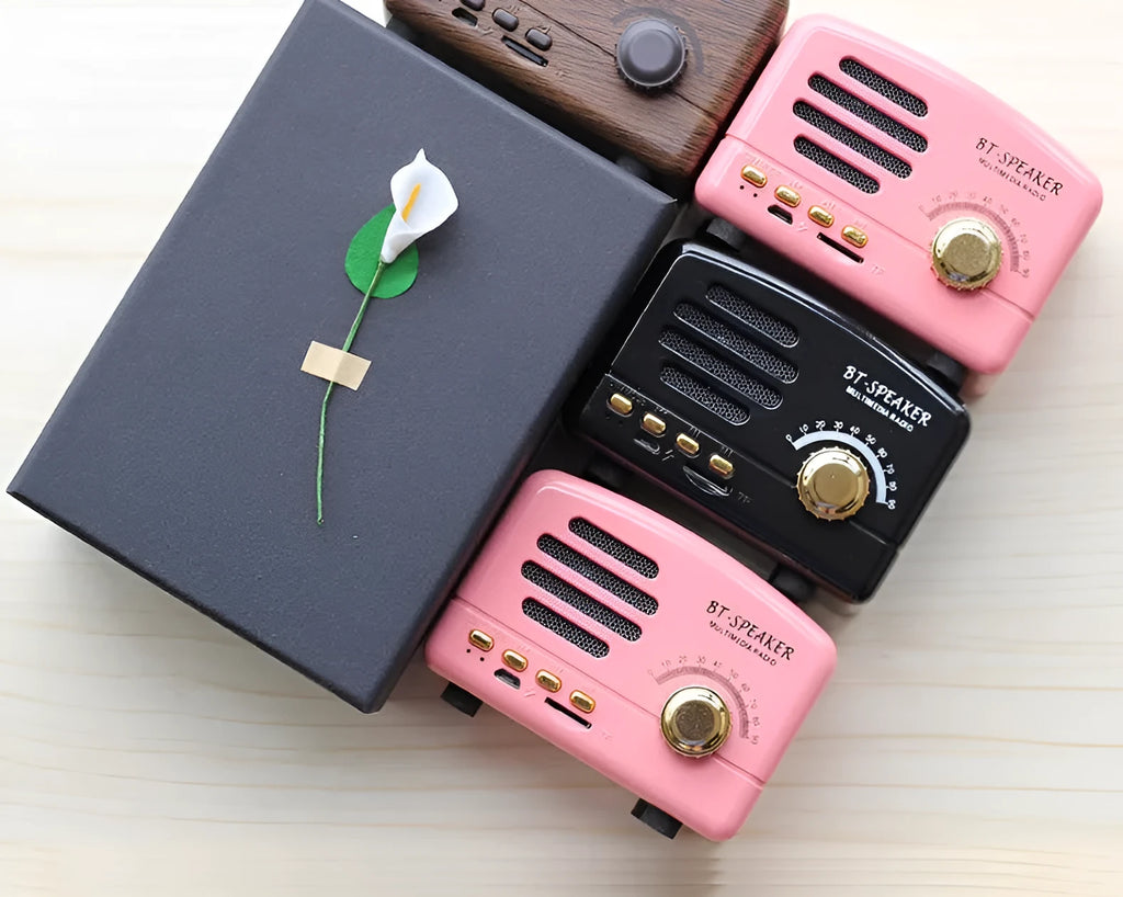 Vintage-style wood-effect Bluetooth speaker in black, pink, and wood grain colour options.
