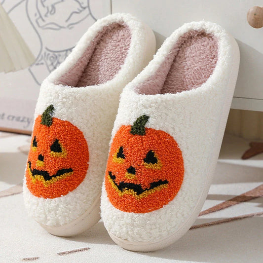 Cozy Halloween-themed pumpkin slippers in white and black colors, featuring soft suede uppers and durable rubber soles for indoor wear