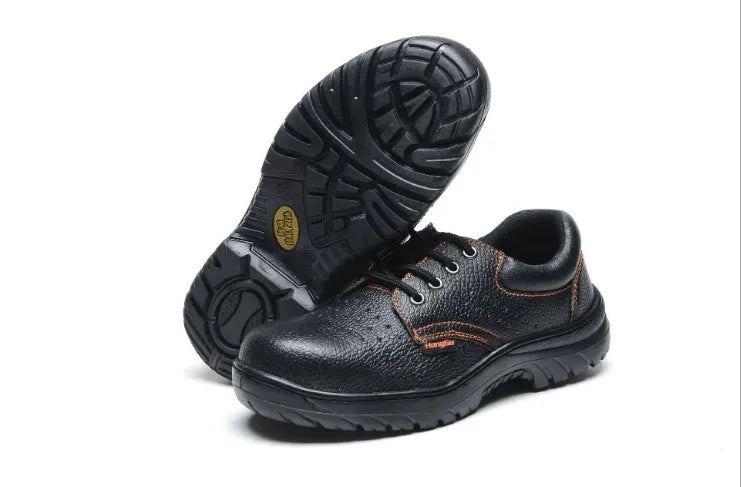 Black embossed cowhide safety shoes with steel toe cap and antiskid outsole on concrete floor