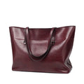 Brown cowhide leather cross body ladies handbag showing two main compartments and internal phone pouch.