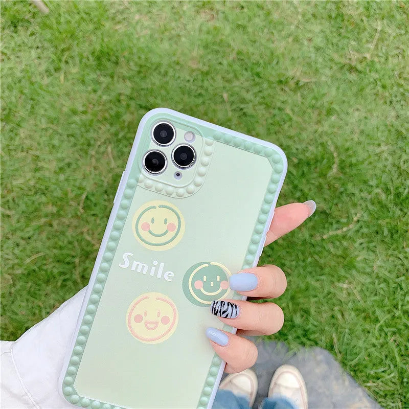 Green TPU iPhone back cover with geometric pattern featuring smiley faces and a polka dot frame.