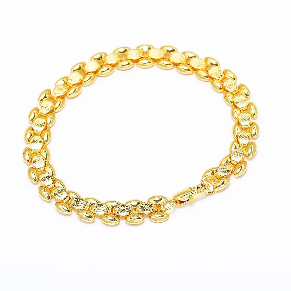 L254 Gold iron bracelet laid flat on a surface, showing its metallic finish and simple design.