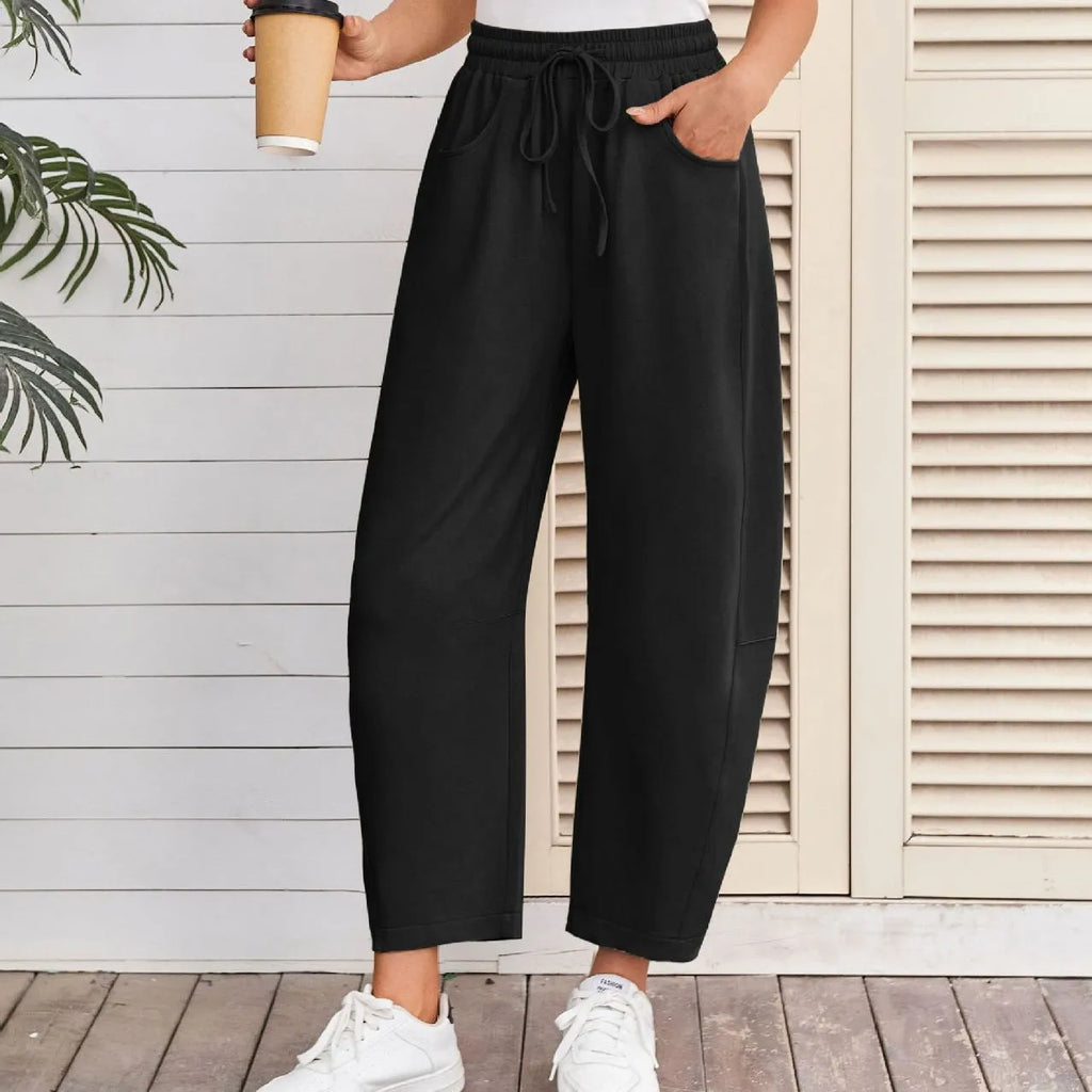 Loose cropped sports sweatpants with elastic waistband and drawstring pockets in street fashion style