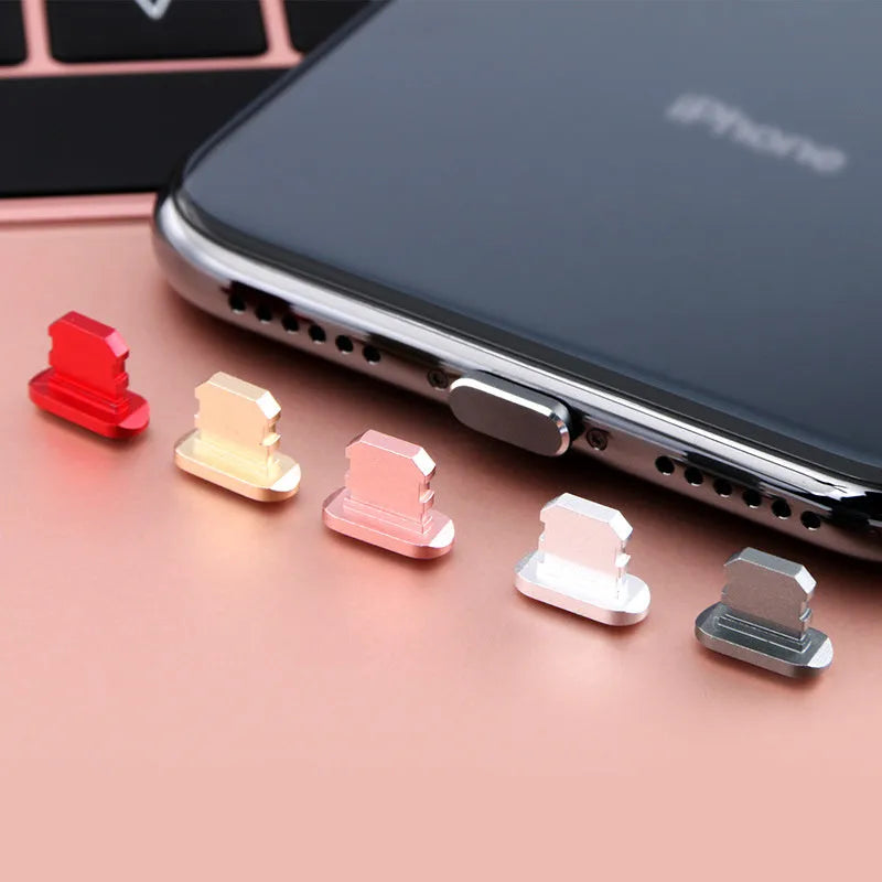 Aluminium alloy iPhone charging port dust plug in silver, shown next to an iPhone.