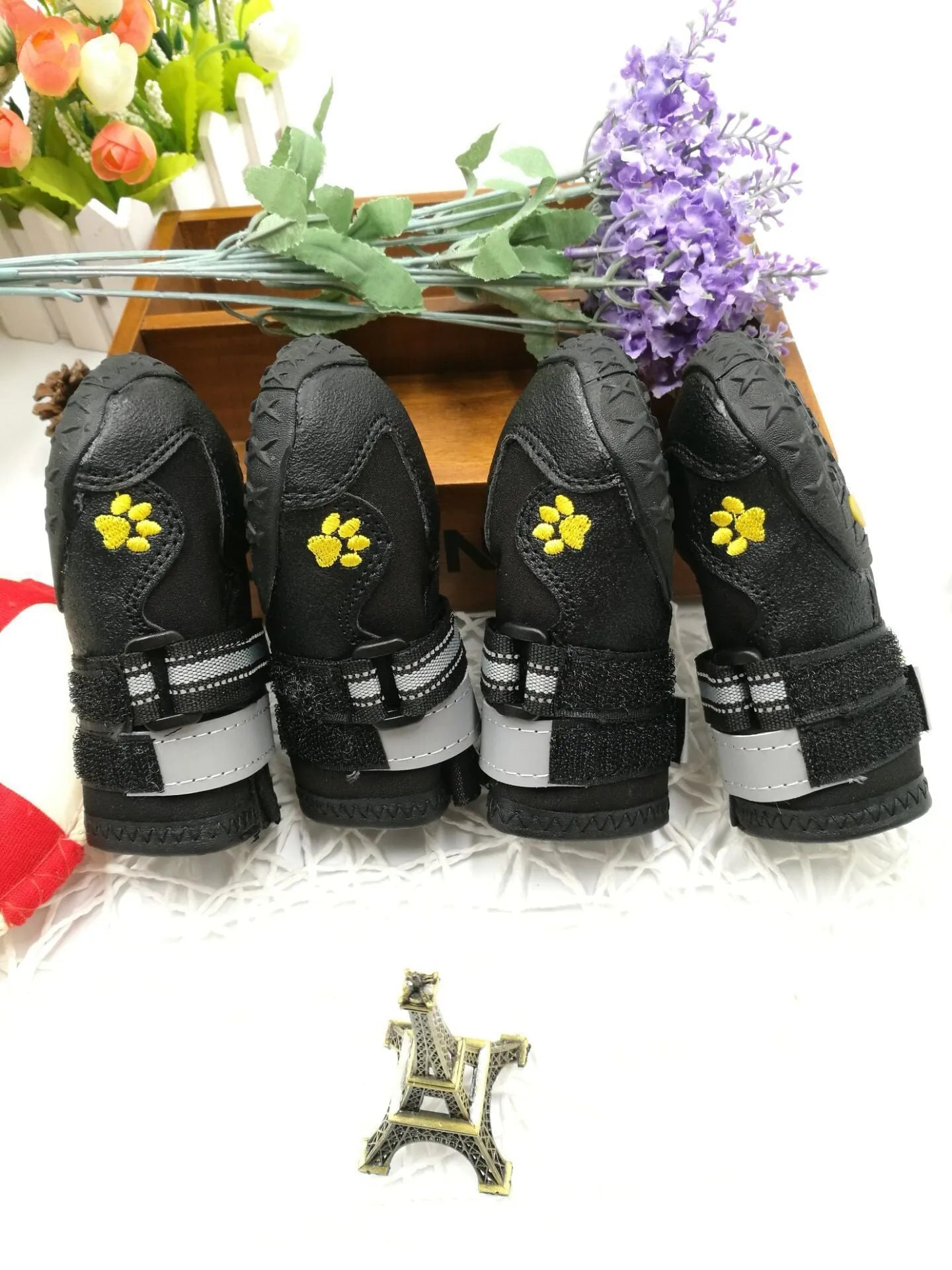Black dog shoes with waterproof PVC sole and adjustable fuzzy belt on a white background