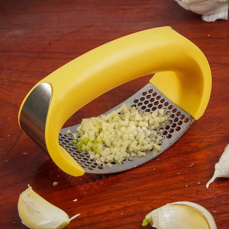 Stainless steel garlic press with curved ergonomic design and non-slip handle in assorted colours.