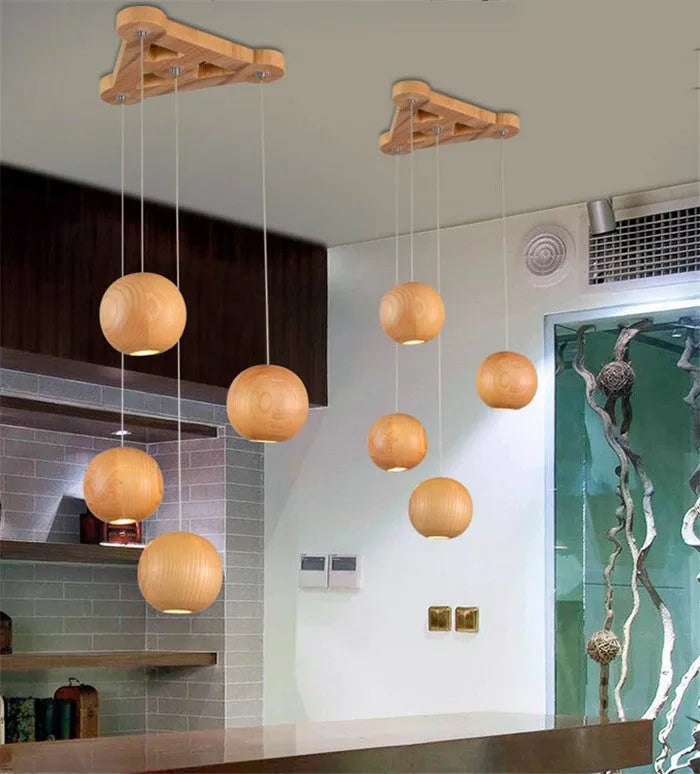 Nordic style solid wood ball chandelier hanging from a ceiling with an adjustable cord.