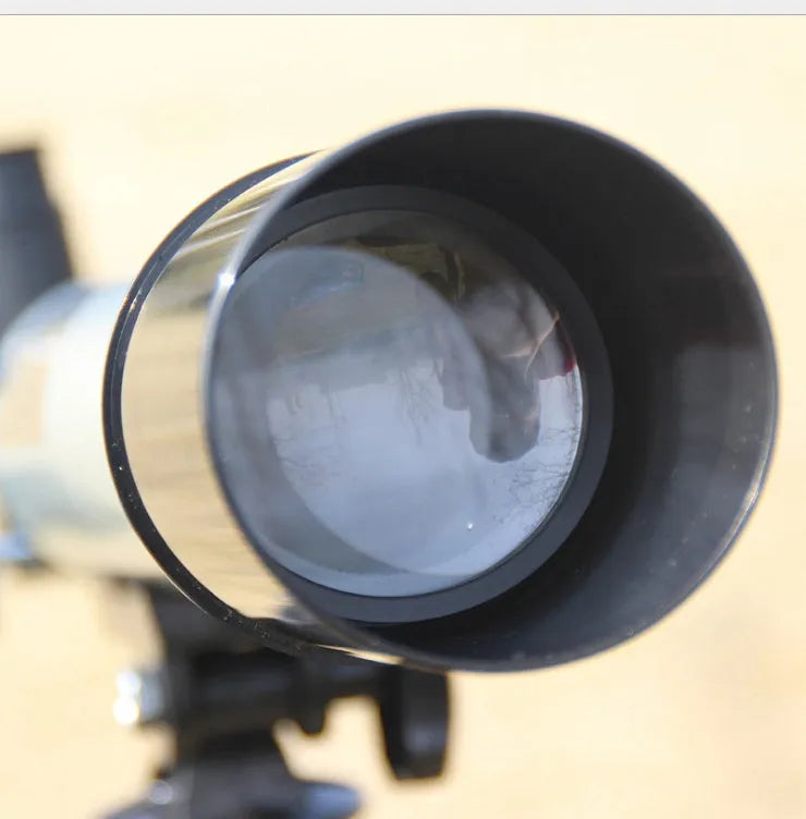 Silver telescope on aluminium tripod with multiple eyepieces and moon lens for stargazing