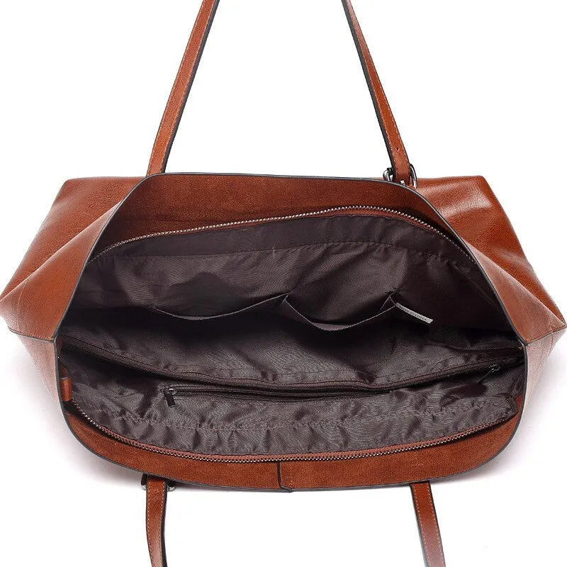 Brown cowhide leather cross body ladies handbag showing two main compartments and internal phone pouch.